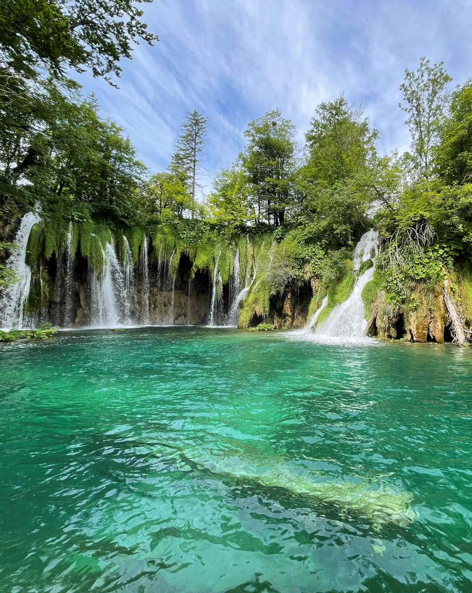 Plitvice Lakes National Park waterfalls cascading into crystal clear green water in Croatia